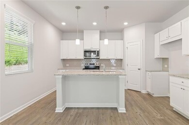 Kitchen with stainless steel appliances, light wood finished floors, backsplash, a sink, and recessed lighting