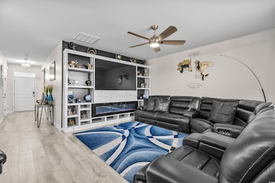 Living area with a ceiling fan and wood finished floors