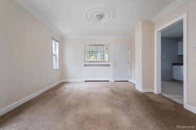 Unfurnished room featuring radiator, crown molding, and light colored carpet