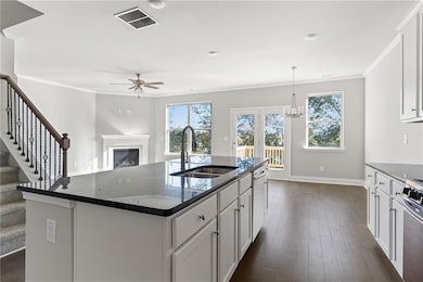 Kitchen featuring a ceiling fan, a sink, ornamental molding, and visible vents