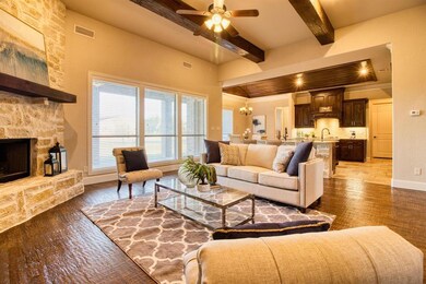 The impressive stone fireplace is paired perfectly with wood beams which creates such a warm gathering place for your family!