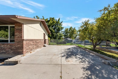 View of property exterior with brick siding and concrete driveway