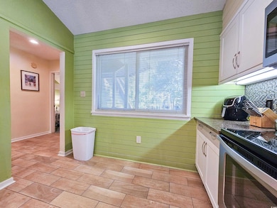 Kitchen with white cabinetry, light tile patterned
