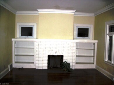 First floor living room with hardwood floors and leaded glass front windows.