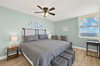 Bedroom featuring ceiling fan, baseboards, and woo