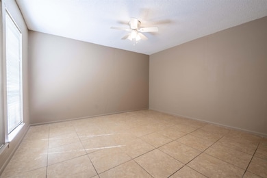 Unfurnished room featuring a textured ceiling, a w