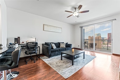 Living room featuring a desk, ceiling fan, wood fi