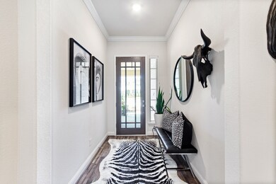 A welcoming grand foyer boasts a gorgeous glass & wood front door.