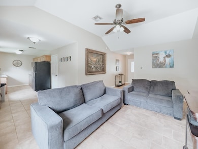 Tiled living room with vaulted ceiling and ceiling fan