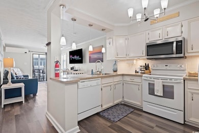 Kitchen with ornamental molding, white appliances, open floor plan, white cabinets, and tasteful backsplash