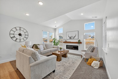 Living room with vaulted ceilings and fireplace.