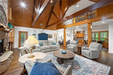 Living room featuring high vaulted ceiling, a ston