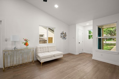Living area with wood finished floors, lofted cei