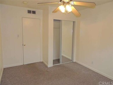 Carpeted bedroom with closet and ceiling fan