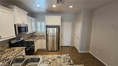 Kitchen featuring a sink, white cabinets, visible