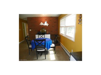 Bright ceramic tiled dining room with brick accent