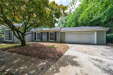 Single story home featuring concrete driveway and an attached garage