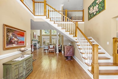 Stairs featuring a high ceiling, hardwood / wood-style flooring, and baseboards