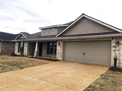 Craftsman-style home with brick siding, concrete driveway, an attached garage, board and batten siding, and a porch