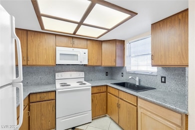 Kitchen with light tile patterned floors, white ap