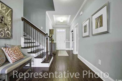 Foyer entrance with wood finished floors, crown molding, and stairs