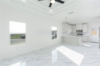 Kitchen featuring light countertops, stainless steel appliances, marble finish floor, visible vents, and white cabinets