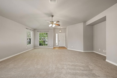 Spare room with light carpet, a ceiling fan, and 