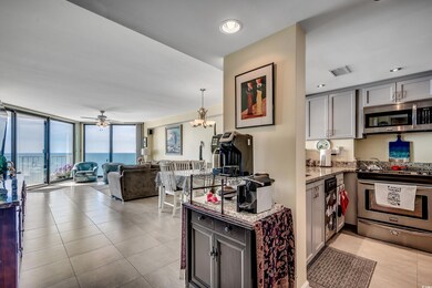 Kitchen featuring stainless steel appliances, light stone counters, light tile patterned flooring, open floor plan, and ceiling fan