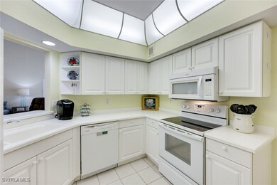 Kitchen with white appliances, light tile patterne