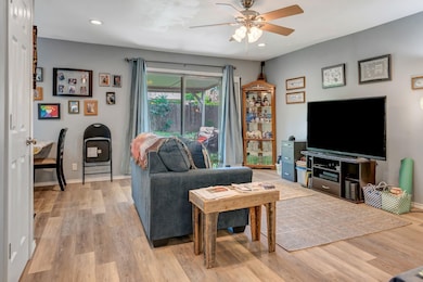 Living room featuring light wood finished floors, ceiling fan, and recessed lighting
