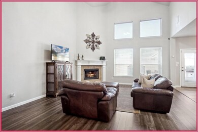 Living room with a towering ceiling, a tile firepl