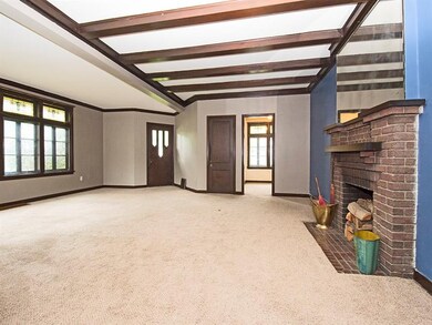 Grand sized living room with beamed ceiling, windo