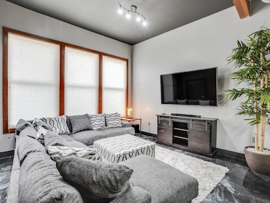 Living room featuring concrete flooring and rail l