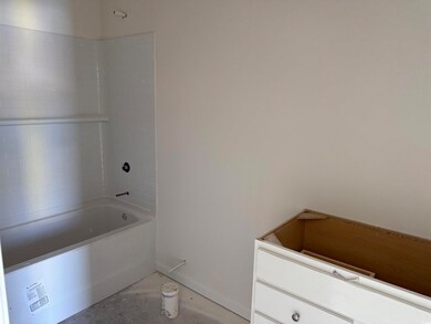 Full bath with baseboards, concrete floors, and ba