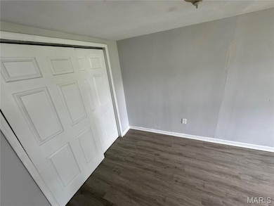 Unfurnished bedroom featuring dark wood-type flooring and a closet