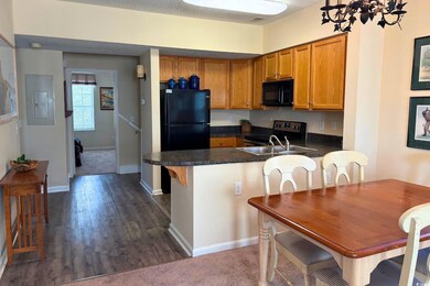Kitchen featuring dark countertops, dark wood-type flooring, black appliances, electric panel, and a textured ceiling