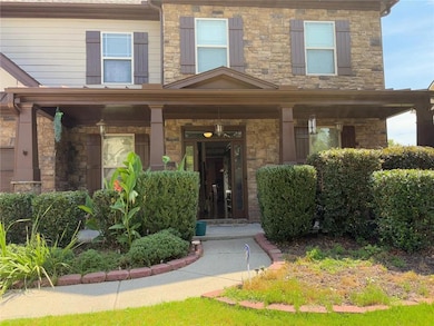 Entrance to property featuring covered porch and stone siding