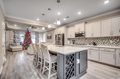 Kitchen featuring a kitchen island with sink, hang