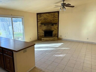 Living room with tile floor and woodburning firepl