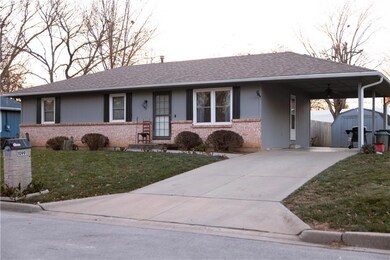 Ranch-style house with a carport, a storage shed, and a front yard
