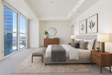 Bedroom with light carpet and a tray ceiling