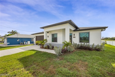 View of front of property with stucco siding, concrete driveway, and an attached garage