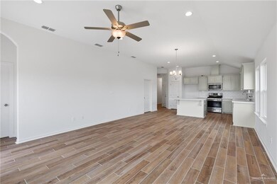 Unfurnished living room with a sink, recessed lighting, ceiling fan, vaulted ceiling, and light wood finished floors
