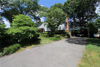 Paved driveway with one covered parking space.