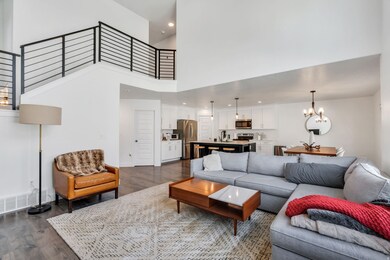 Living room featuring dark wood-type flooring, a chandelier, a high ceiling, and recessed lighting