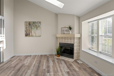 Living room w/ electric fireplace and bay window.