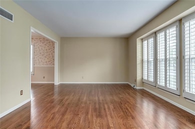 Unfurnished room with wood finished floors and baseboards