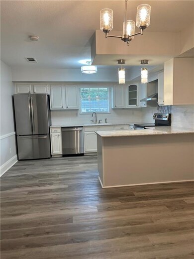Kitchen features quartz countertops, white cabinet