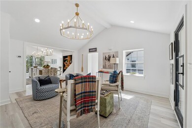 Living room with lofted ceiling with beams, a heal
