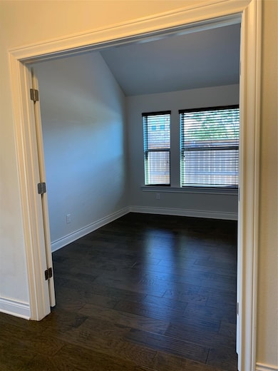Spare room with lofted ceiling and dark wood-styl